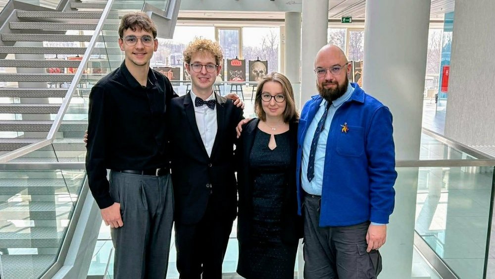 cztery osoby studenckie na tle klatki schodowej